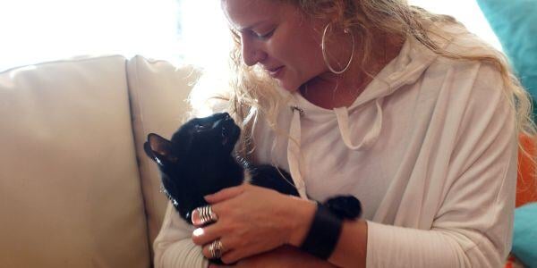 woman hugging a black cat